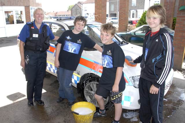Flamborough Lifestyle cash washers Sam Crimlisk, 12, Cory Jones, 13, Keiran Crosthwaite, 12, with PCSO Beverley Feirn in 2010. (ps1034-21)