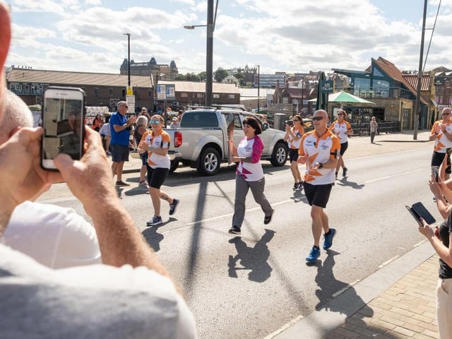 Tracey Romaine takes part in The Queen's Baton Relay as it visits Scarborough South Bay.