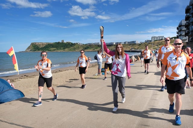 The baton makes its way to the final destination outside the North Bay beach chalets.