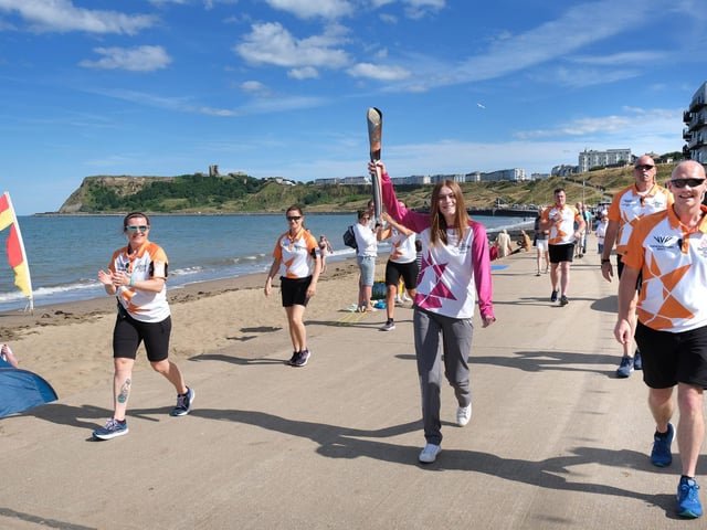 The baton makes its way to the final destination outside the North Bay beach chalets.