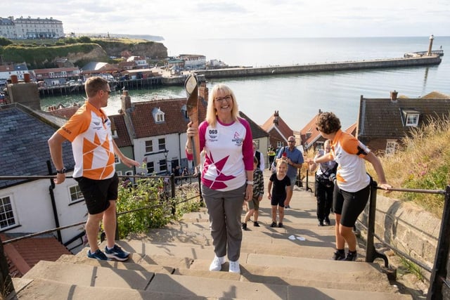 Julie Lee, Gary Matalon and Amy Gustin take part in the relay as it climbs the 199 steps on its way Whitby Abbey