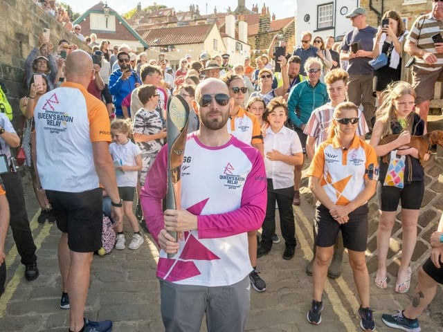 Bruce McClean takes part in The Queen's Baton Relay as it visits Robin Hood's Bay.