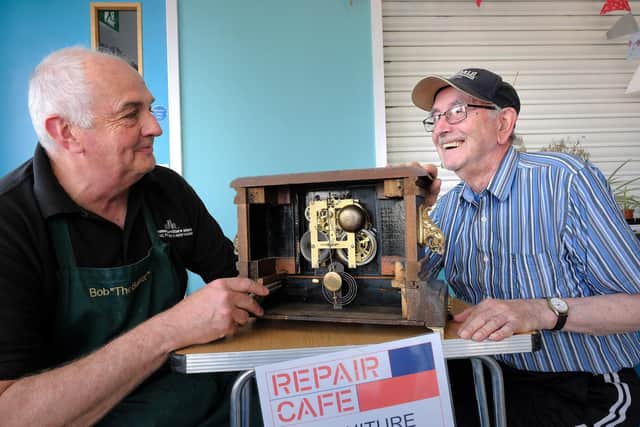 Bob Bunce looks at the clock Ray Dobson has brought in.
