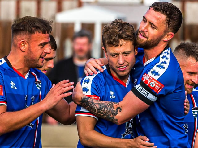 Jon Burn, left, and Dan Rowe, right congratulate the scorer of Town's opener Jake Hackett