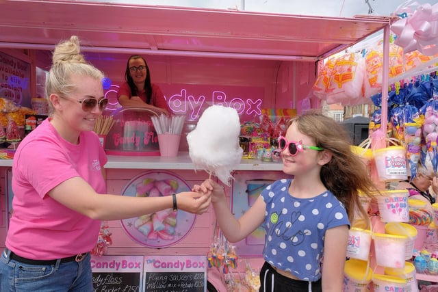 Olivia Smith of the Candy Box presents Kayleigh Randle with some candy floss as Melissa Rainton looks on.