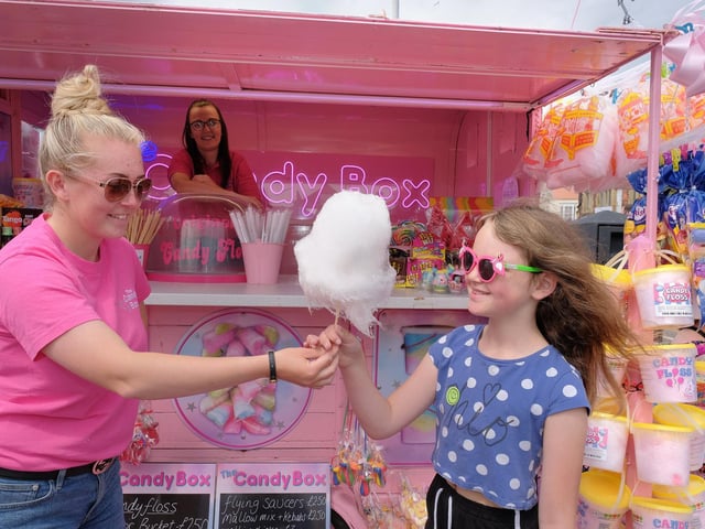 Olivia Smith of the Candy Box presents Kayleigh Randle with some candy floss as Melissa Rainton looks on.