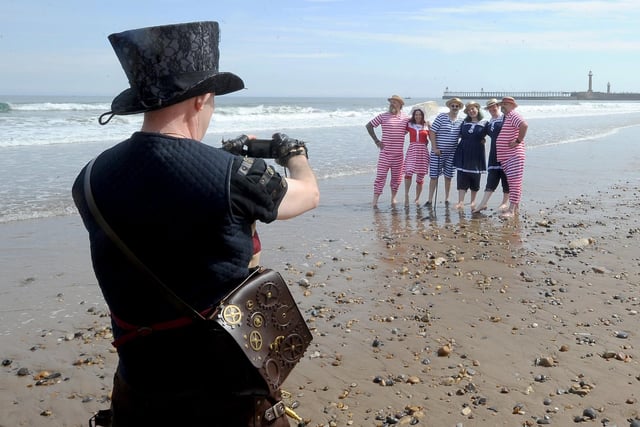 Steampunk visitors pose for a snap by the sea.