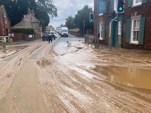 Water and sand washes over the road before sinkhole emerges.
