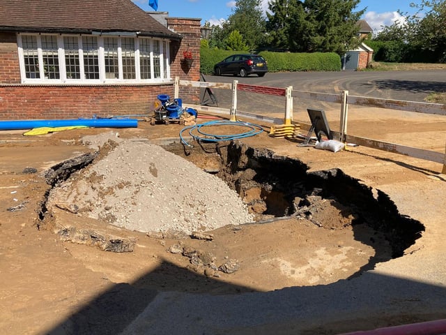 The damage to the road caused by the sinkhole.