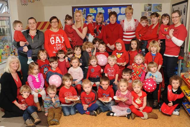 Children and staff at Cliffe House Nursery, on Third Avenue, wear red to raise funds for Leeds General Infirmary in 2013. Do you recognise any of the people in the picture? Photograph taken by Paul Atkinson (NBFP-PA1309-4)