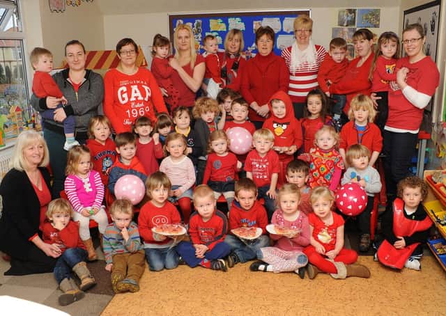 Children and staff at Cliffe House Nursery, on Third Avenue, wear red to raise funds for Leeds General Infirmary in 2013. Do you recognise any of the people in the picture? Photograph taken by Paul Atkinson (NBFP-PA1309-4)