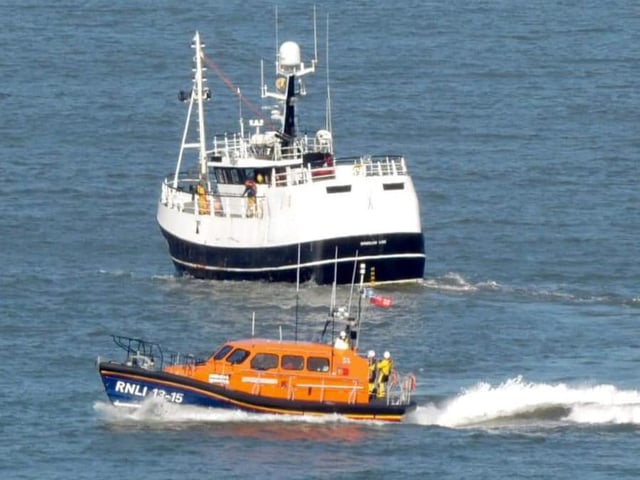 The lifeboat near the fishing vessel.
