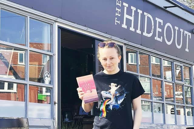 Hannah Green outside The Hideout with her book, My Journey Home.