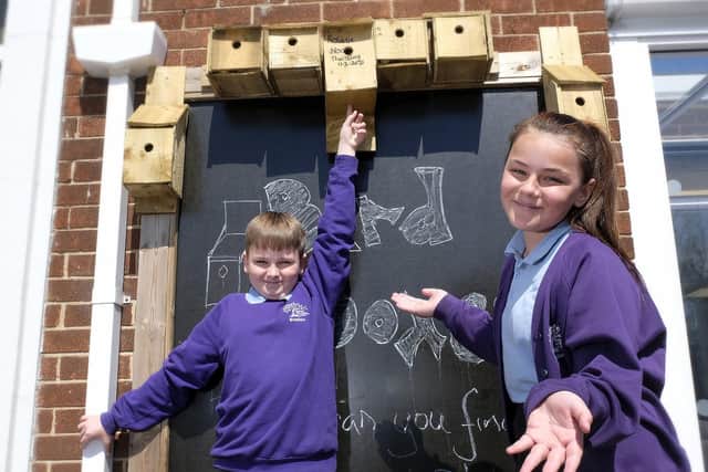 Pupils Jake and Tamsin with the bird boxes in the garden.