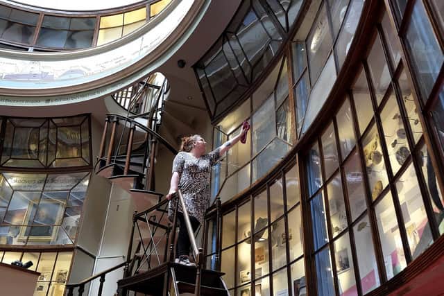 Cassie Taal cleaning the exhibition glass the Rotunda Museum