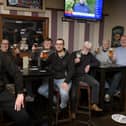 Landlord Danny Smith, left, celebrates with customers at Scholars Bar.
