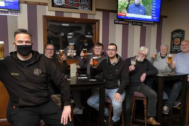 Landlord Danny Smith, left, celebrates with customers at Scholars Bar.