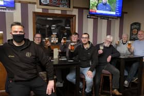 Landlord Danny Smith, left, celebrates with customers at Scholars Bar.