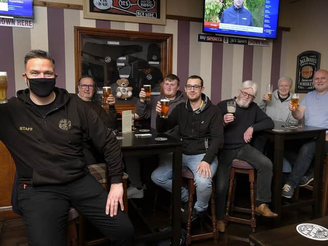 Landlord Danny Smith, left, celebrates with customers at Scholars Bar.