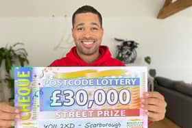 Danyl Johnson with the winning cheque. Picture: People's Postcode Lottery