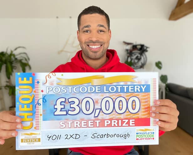 Danyl Johnson with the winning cheque. Picture: People's Postcode Lottery