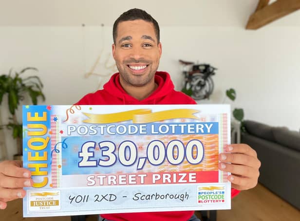 Danyl Johnson with the winning cheque. Picture: People's Postcode Lottery