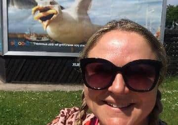 Hannah poses in front of a billboard featuring her photograph in Leeds.