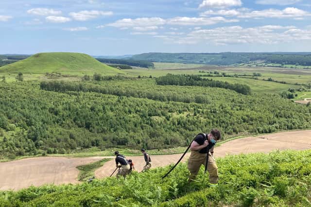 Fire crews hauling a hose up the bank from where the blaze was at the Hole of Horcum, near Whitby.
picture: North Yorkshire Fire & Rescue.