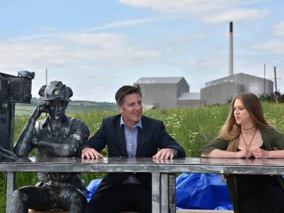 Boulby General Manager Andrew Fulton and artist Katie Ventress sit alongside the miners statue which forms a major element of the sculpture.