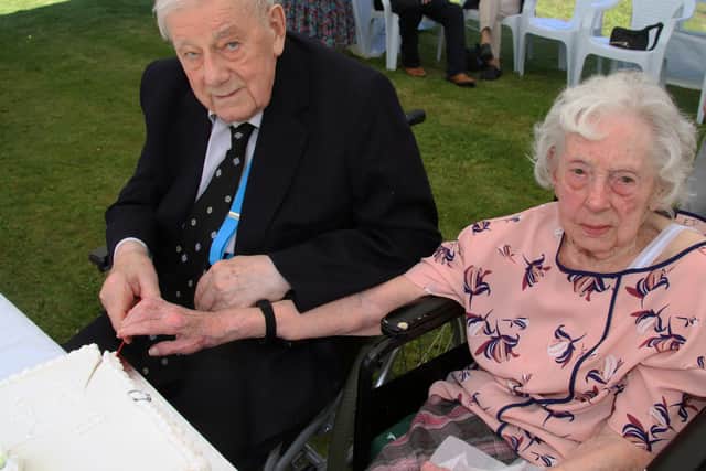 Ken and Betty recreate cutting the wedding cake during the celebrations.