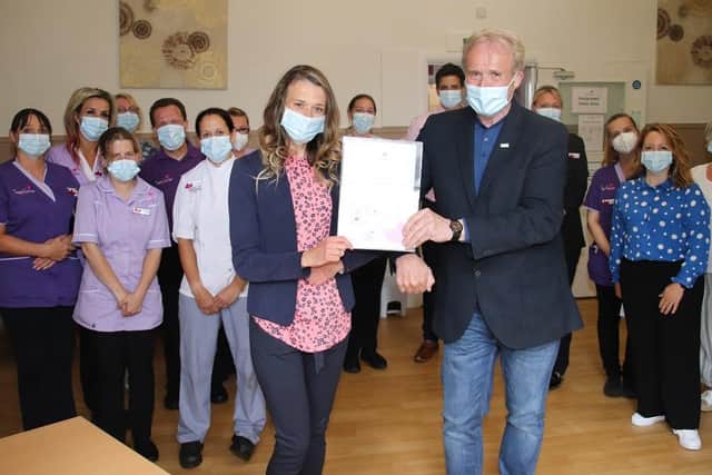 Kasia Kapuscinska receives her long service award from Saint Cecilia’s Managing Director Mike Padgham, watched by fellow long service award recipients and colleagues at Saint Cecilia’s Nursing Home in Scarborough
