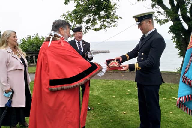 Royal Navy Lieutenant, David Jackson, presents the Mayor with the HMS Duncan Coat of Arms, on behalf of the ship’s captain.