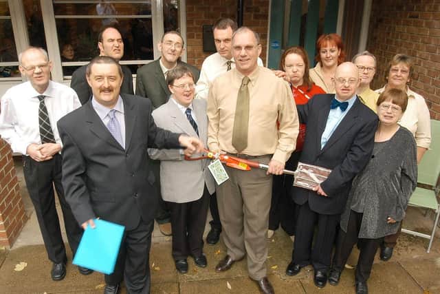 David Robinson (middle) is pictured with the residents of Kirkgate House while holding his gift of a garden fork as he retires in 2003. (PA0344-24)