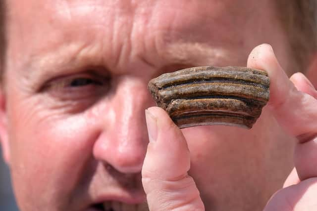 Phoenix Court owner Mike Buttery makes a discovery at the dig site.