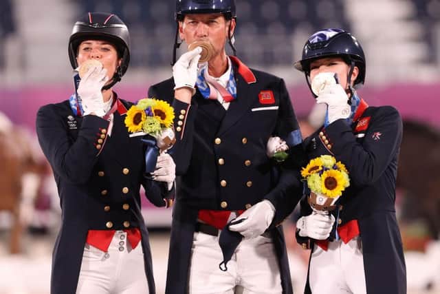 Team GB's bronze medalists Charlotte Dujardin, left, Carl Hester and Charlotte Fry pose on the podium during the medal ceremony. (Photo: Julian Finney/Getty)