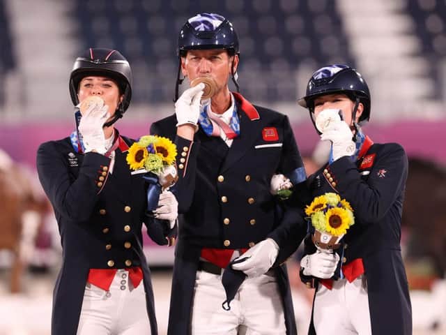 Team GB's bronze medalists Charlotte Dujardin, left, Carl Hester and Charlotte Fry pose on the podium during the medal ceremony. (Photo: Julian Finney/Getty)