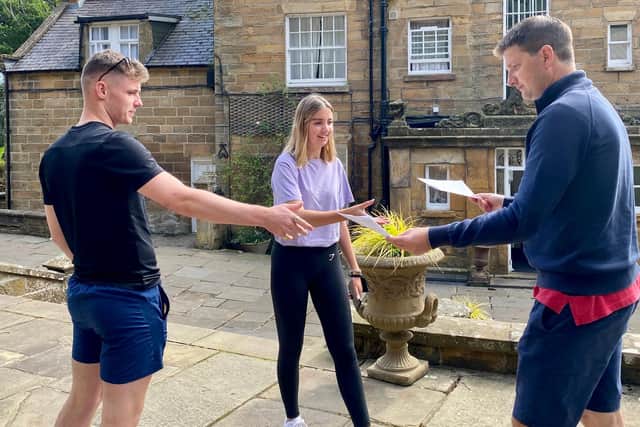 Geography students Rory and Pheobe receive their A-level results from Fyling Hall head Steven Allen.