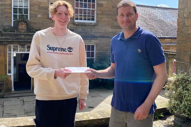 Fyling Hall School Headmaster Steven Allen presents Joe with his top grades.