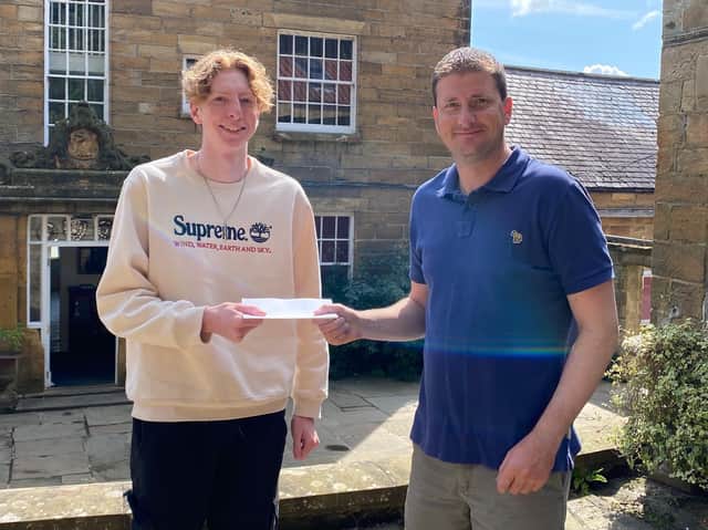 Fyling Hall School Headmaster Steven Allen presents Joe with his top grades.