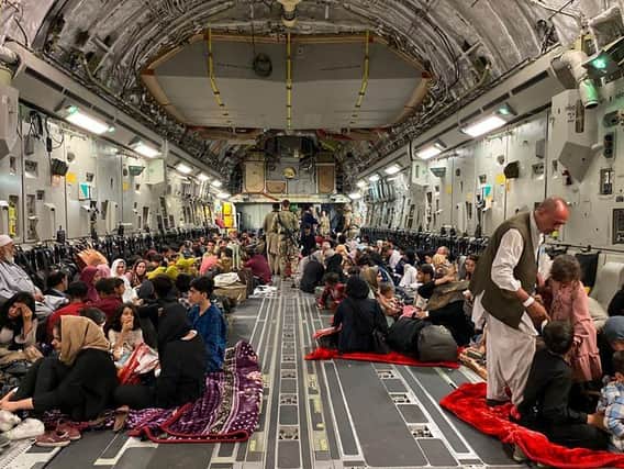 Afghan people sit inside a US military aircraft to leave Afghanistan, at the military airport in the capital Kabul. (Photo: Shakib Rahmani/Getty)