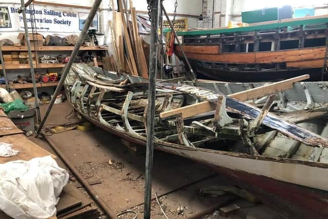 Old planks are stripped off the coble Venus ready for replacements to be fitted.