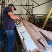 John Clarkson and Malcolm Smales get to work on the coble Venus inside the workshop at Beck Hill in Bridlington.