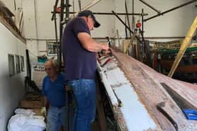 John Clarkson and Malcolm Smales get to work on the coble Venus inside the workshop at Beck Hill in Bridlington.