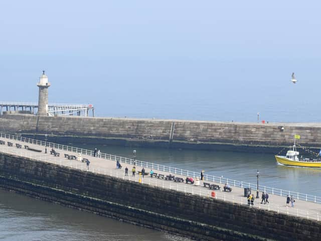 People enjoying a walk along the pier at Whitby in hazy sunshine.
Picture by Gary Longbottom.
