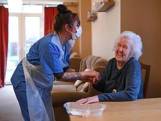 A care home resident and care staff. (Getty Images)