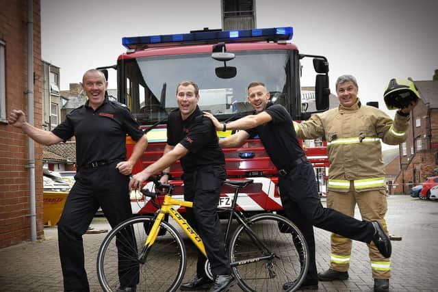 Firefighters Steve King, left, Scot Wilson, David Elliot and cheered on by Mike McNaughton.