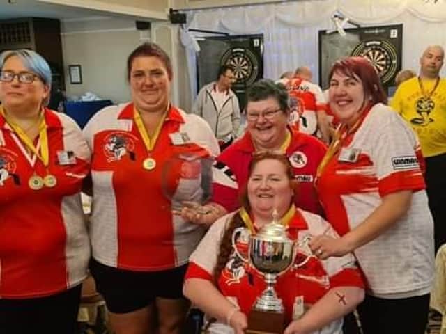 Karen Barber holds the World Cup with her England teammates