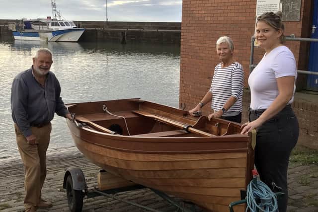 Mike Eckles, his wife Sue, and daughter Charlotte are pictured with the new sailing dingy.