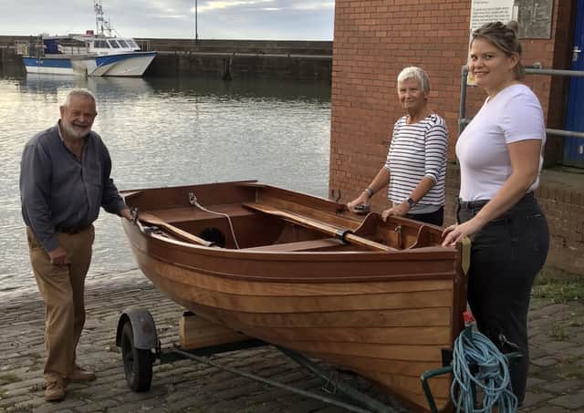 Mike Eckles, his wife Sue, and daughter Charlotte are pictured with the new sailing dingy.