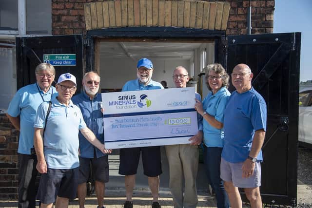 Men's Shed chairman Iain Hale receives a 10,000 cheque to help finance the new facility.